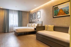 宿务Primeway Suites Cebu的酒店客房设有两张床和窗户。