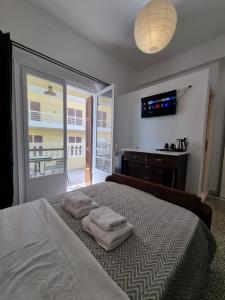 斯巴达Hall Apartments & Rooms - by Avelink的一间卧室配有一张床,上面有两条毛巾