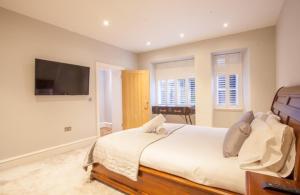 格拉斯哥Stylish 2 Bedroom Apartment In Park Circus, West End的一间卧室配有一张大床和一台平面电视
