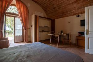 里奥托尔托Appartamento Pianosa的一间卧室配有一张床铺和一张桌子,还设有一间厨房