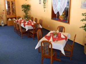 埃伦德瓦尔德木和勒酒店的用餐室配有桌椅和红白桌布