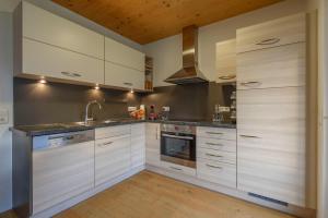 巴德哥依斯恩Ferienlodge MaResi的厨房配有白色橱柜和不锈钢用具