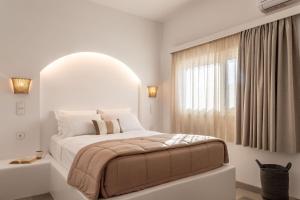 卡尔扎迈纳Euphoria Suites and Spa的白色的卧室设有一张大床和一个窗户