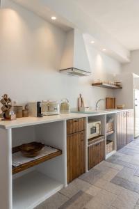 卡尔扎迈纳Euphoria Suites and Spa的厨房配有白色的柜台和木制橱柜。