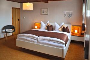 马瑟尔贝格Ferienwohnung "An den Kurwiesen"的一间卧室配有一张大床、两盏灯和一把椅子