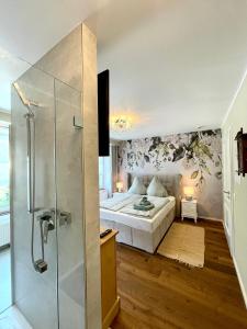 维宁根Moselblick Winningen Traumwohnung im „La Mosel“的一间卧室设有一张床和一个玻璃淋浴间