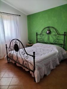 雷阿尔蒙特Pergole的一间卧室配有一张带绿色墙壁的床