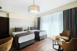 伊斯坦布尔Orka Taksim Suites & Hotel的酒店客房设有两张床和一张桌子。