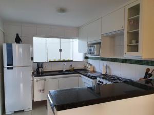 塞古罗港Casa Duplex Aconchegante de Frente para o Mar的厨房配有白色橱柜和白色冰箱。