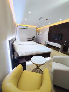 尼兹瓦Nizwa Inn - نزوى إن的酒店客房配有床、沙发和电视。