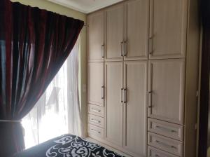 哈尔基斯Διαμέρισμα για 4 με θέα θάλασσα σε ήσυχη γειτονιά的卧室配有白色橱柜和窗户。