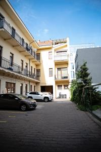 科希策Cozy modern apartment in the Old Town - Hlavna street的两辆汽车停在大楼前的停车场