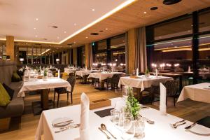 乌登斯Sportresidenz Zillertal - 4 Sterne Superior的餐厅设有白色的桌椅和窗户。