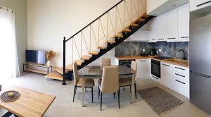 希俄斯Almeta Suites的厨房以及带桌子和楼梯的用餐室。