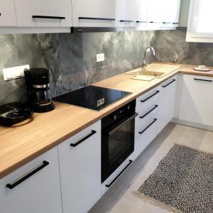 希俄斯Almeta Suites的厨房配有白色橱柜和黑炉灶烤箱。