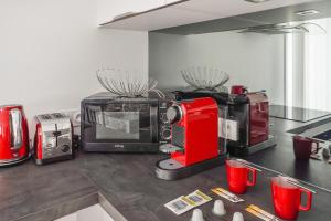 拉罗谢尔Appartement des Tours - Welkeys的柜台上配有红色用具的厨房