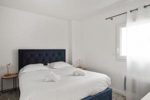 拉罗谢尔Appartement des Tours - Welkeys的卧室配有白色大床和白色枕头