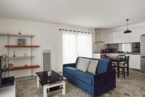 拉罗谢尔Appartement des Tours - Welkeys的一间带蓝色沙发的客厅和一间厨房