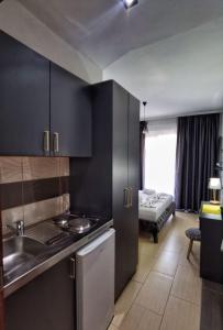 乌尔齐尼MD APARTMENTS的一间带黑色橱柜和水槽的厨房和一间客厅