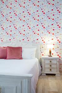 阿尔巴塔克斯B&B Calamoresca的卧室配有白色床和花卉壁纸