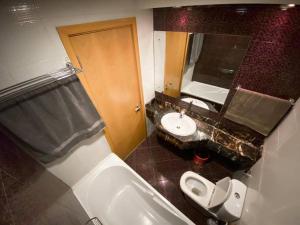 迪拜Cosy Studio in Marina的一间带水槽、卫生间和镜子的浴室