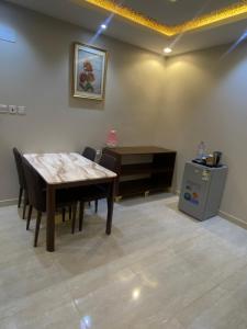 Al ḨanākīyahAl Wissam Golden Hotel的一间带木桌和椅子的用餐室