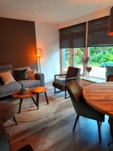霍尔滕Secret Wellness Puur Natuur的客厅配有沙发和桌子