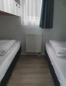 皮滕Klein Ramdal的配有窗户和散热器的客房内的两张床