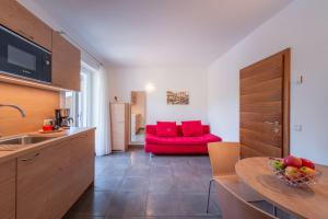 泰尔梅诺Sandhof的厨房以及带红色沙发的起居室。