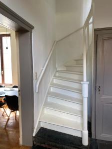 KortessemHuis Louis的一道门的房间里,有白色的楼梯