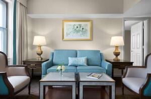 圣路易斯The Royal Sonesta Chase Park Plaza St Louis的客厅配有蓝色的沙发和两把椅子