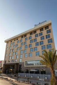 斯法克斯Radisson Hotel Sfax的一座大建筑,前面有棕榈树