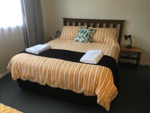 New Haven凯普斯通卡特林斯海滨公寓的一间卧室配有两张带条纹床单的床