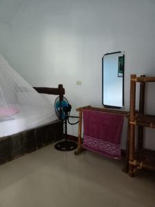 武吉拉旺武吉拉旺棕竹山林小屋的一间卧室配有一张床和一张桌子上的镜子