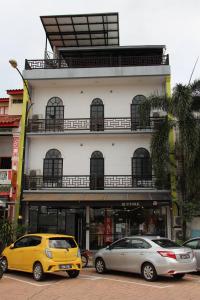 瓜拉丁加奴Hotel Decentraland Kuala Terengganu的两辆汽车停在大楼前