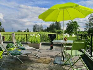 萨尔特-雷斯温泉Le Relais des Fagnes的庭院配有桌椅和遮阳伞。