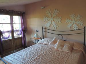 蒙特卡蒂尼泰尔梅伊尔西普莱索加罗公寓的卧室配有一张带雪花壁画的床。