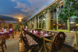 杜尚别Asia Grand Hotel的餐厅配有桌椅和圣诞装饰