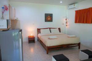 莱姆索塔Heaven Beach Koh Samui的一间卧室配有一张床和一台冰箱