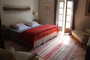 贝济耶Domaine de Manteau-Bleu的一间卧室配有一张带红色毯子的床