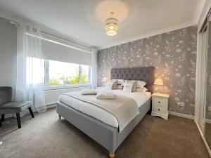 塞拉戴克Dragonfly - HOT TUB luxury two bedroom cottage的一间卧室设有一张大床和一个窗户。