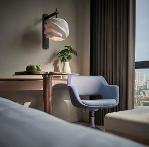 吉隆坡吉隆坡阿玛瑞酒店的一间卧室配有一张床、一张桌子和一把椅子