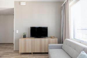 罗瓦涅米Arctic Penthouse City Suite的客厅配有沙发和橱柜上的电视