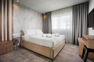 雅典Xclusive Athens Suites的酒店客房设有床和窗户。
