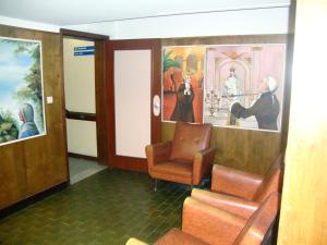 吉马良斯Casa de Retiros N. S. Perpetuo Socorro的一间设有椅子和壁画的等候室