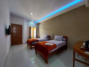 AmpanaOASIS HOTEL的酒店客房带两张床,还有蓝色的灯光