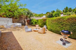 莫莱拉Colina - holiday home with private swimming pool in Moraira的后院设有椅子、烧烤架和山 ⁇ 