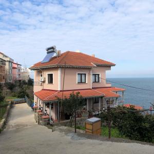 特拉布宗Villa Laila Trabzon的一座红色屋顶和海洋的房子