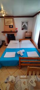 阿斯特里斯Dalis House的一间卧室配有两张蓝色床单