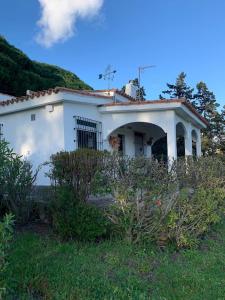 塔里法Finca Dos Vientos Tarifa的一座带草地庭院的白色小房子